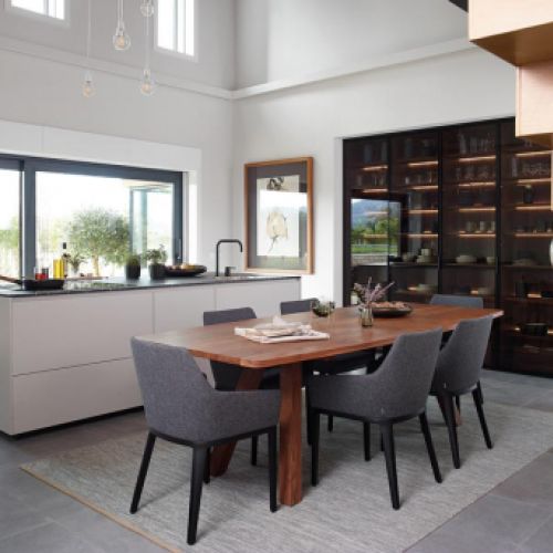 Cocina completa con isla, armario de cristal y mesa con sillas